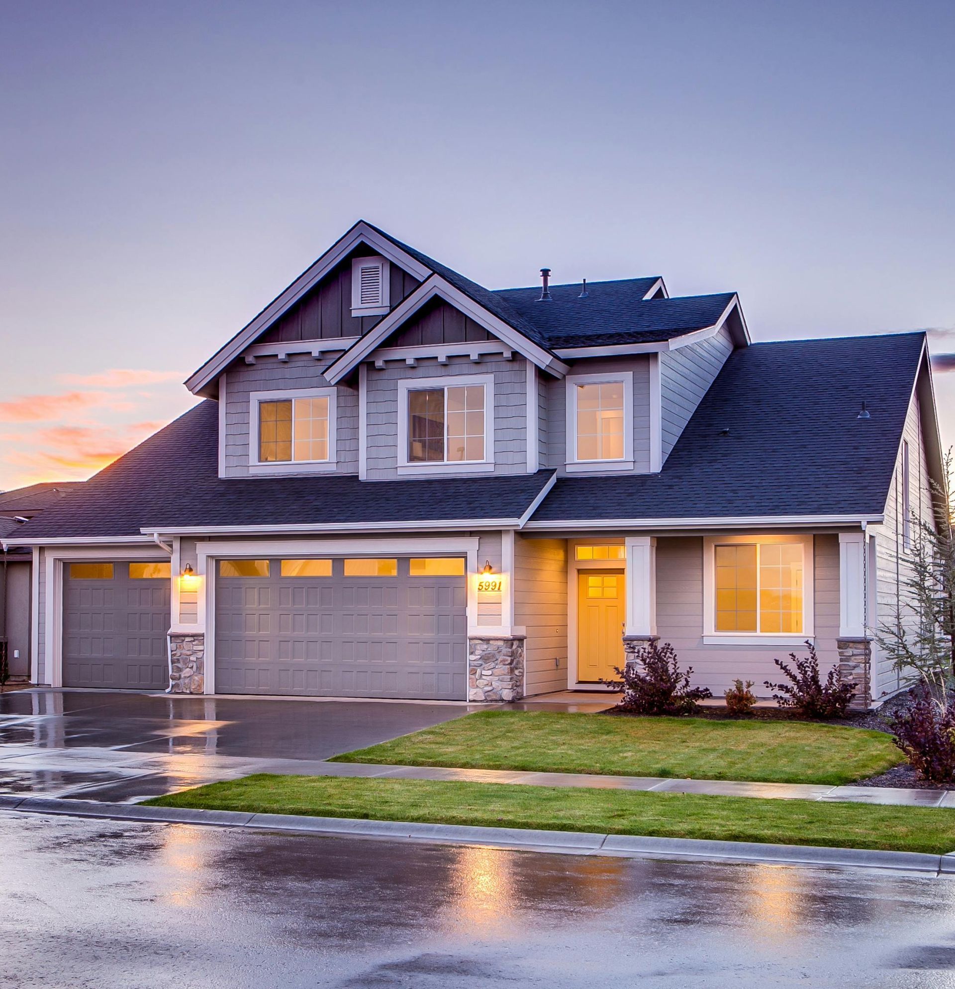 Elegant suburban home with driveway at sunset showcasing modern architecture.