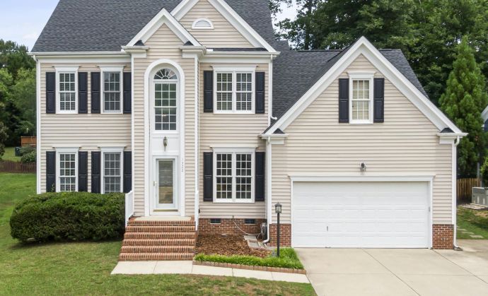 A beautiful two-story suburban home with a lush green lawn in Apex, NC.